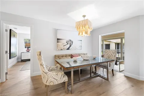 a kitchen with a refrigerator a stove a sink dishwasher and a dining table with wooden floor
