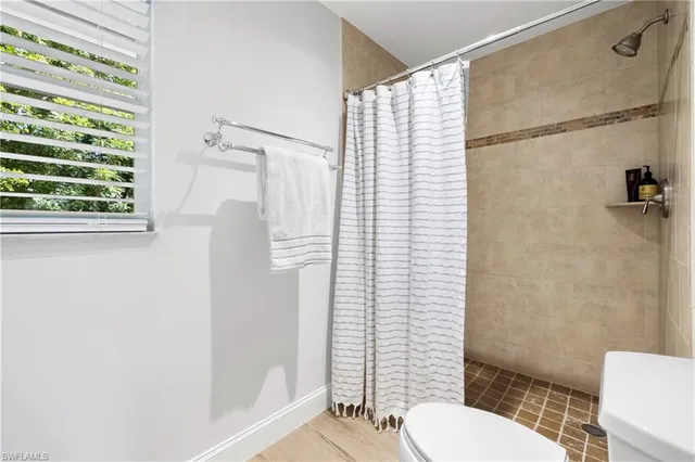 a bathroom with a granite countertop sink toilet a mirror and shower