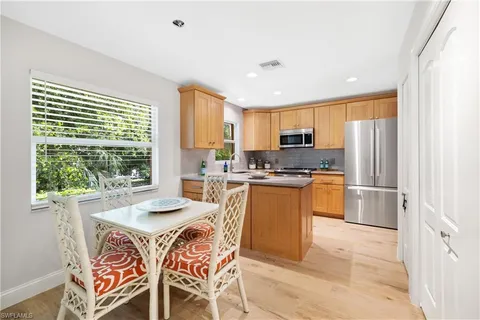 a kitchen with refrigerator a microwave a sink and cabinets