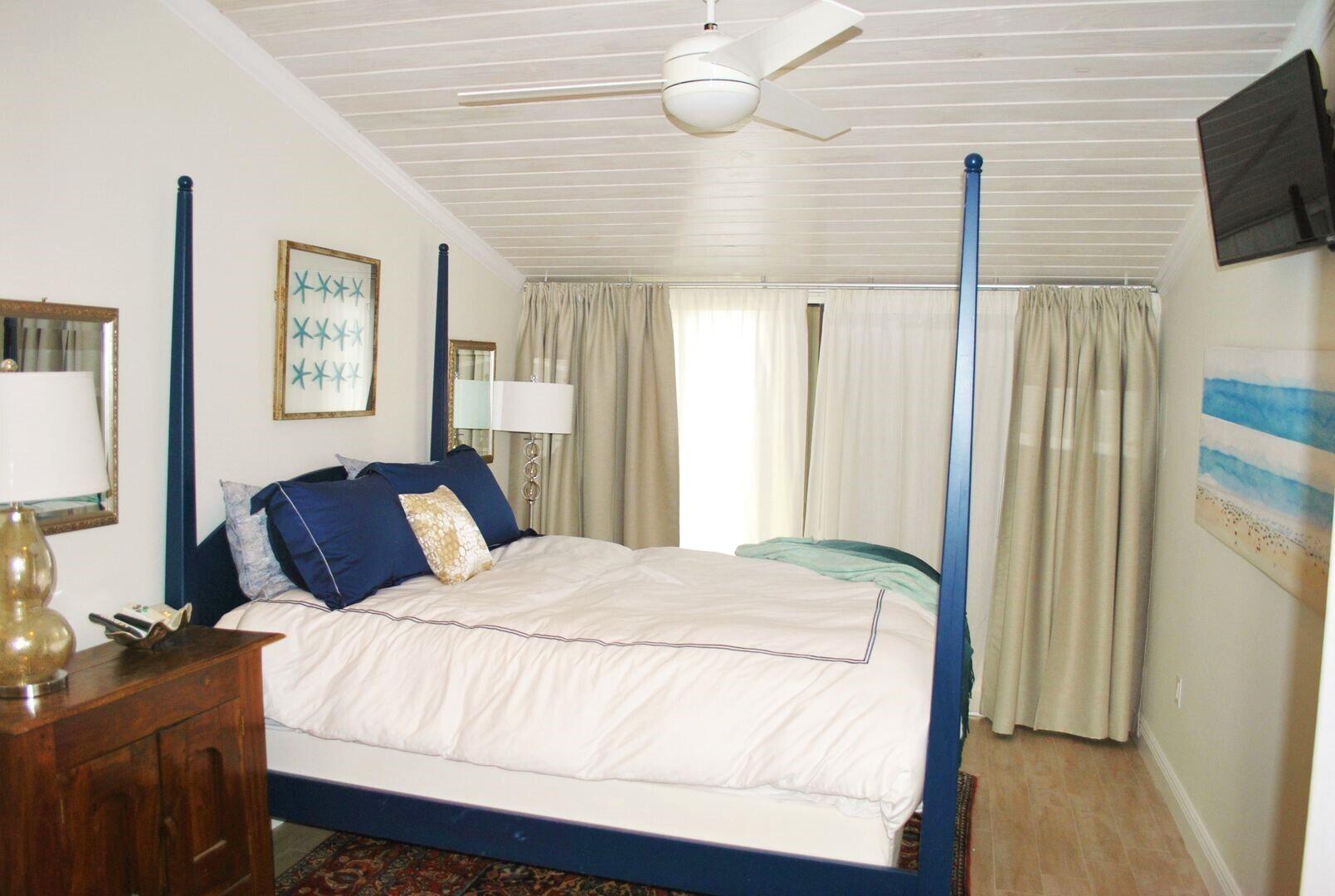 87200 Overseas Highway, Unit G5 Islamorada, FL 33036 - Photo 11 of 21 a bedroom with a bed wooden floor and flat screen tv
