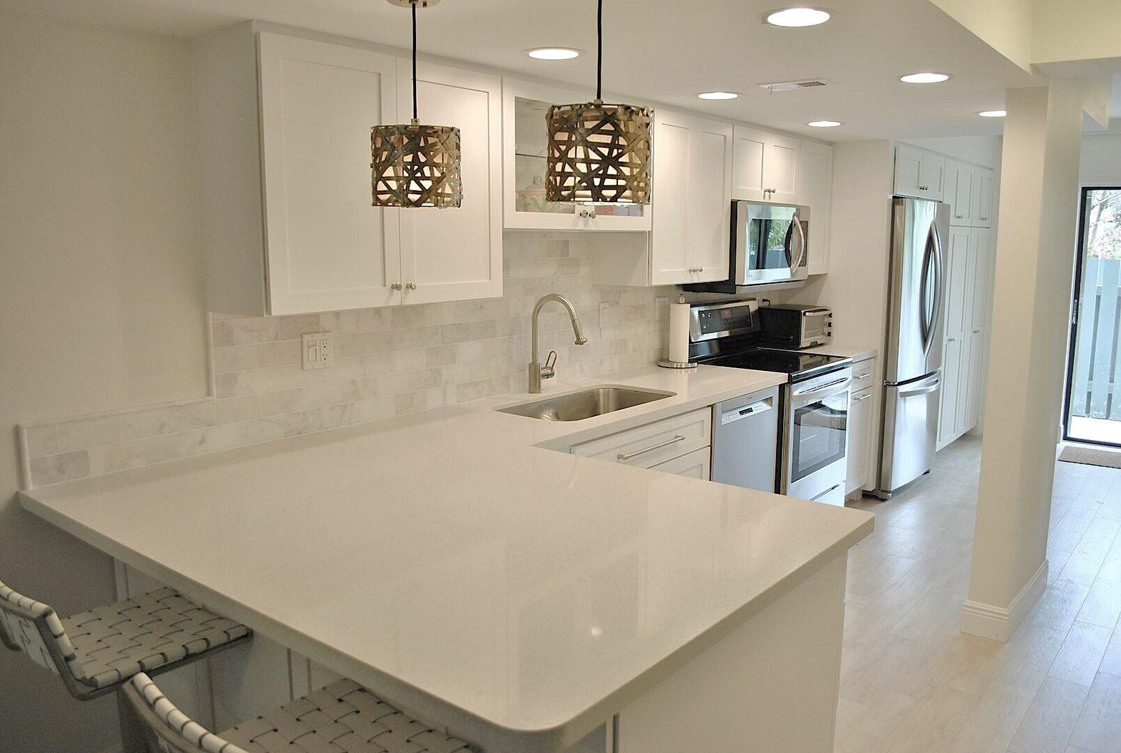 87200 Overseas Highway, Unit G5 Islamorada, FL 33036 - Photo 5 of 21 a kitchen with stainless steel appliances a refrigerator a sink a stove top oven a counter space and cabinets