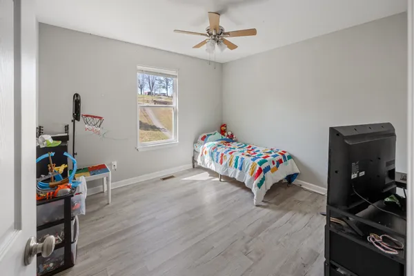 a bedroom with a bed and a wooden floor
