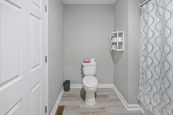 a white toilet sitting next to a white wall