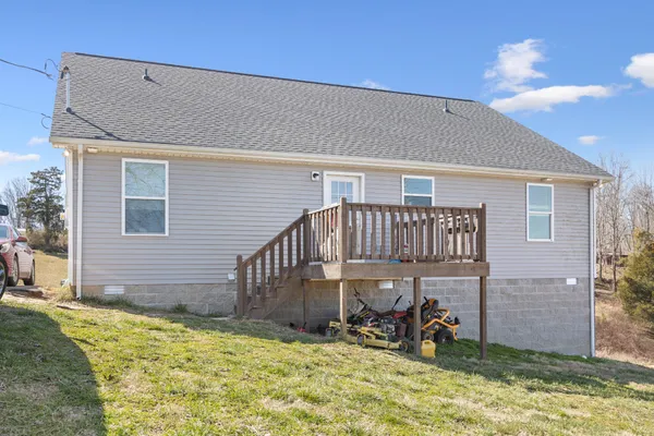a view of a house with large window and wooden fence