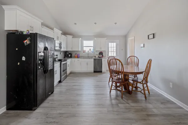a kitchen with stainless steel appliances a dining table chairs and chandelier