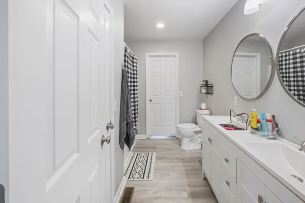 a bathroom with a sink mirror vanity and toilet