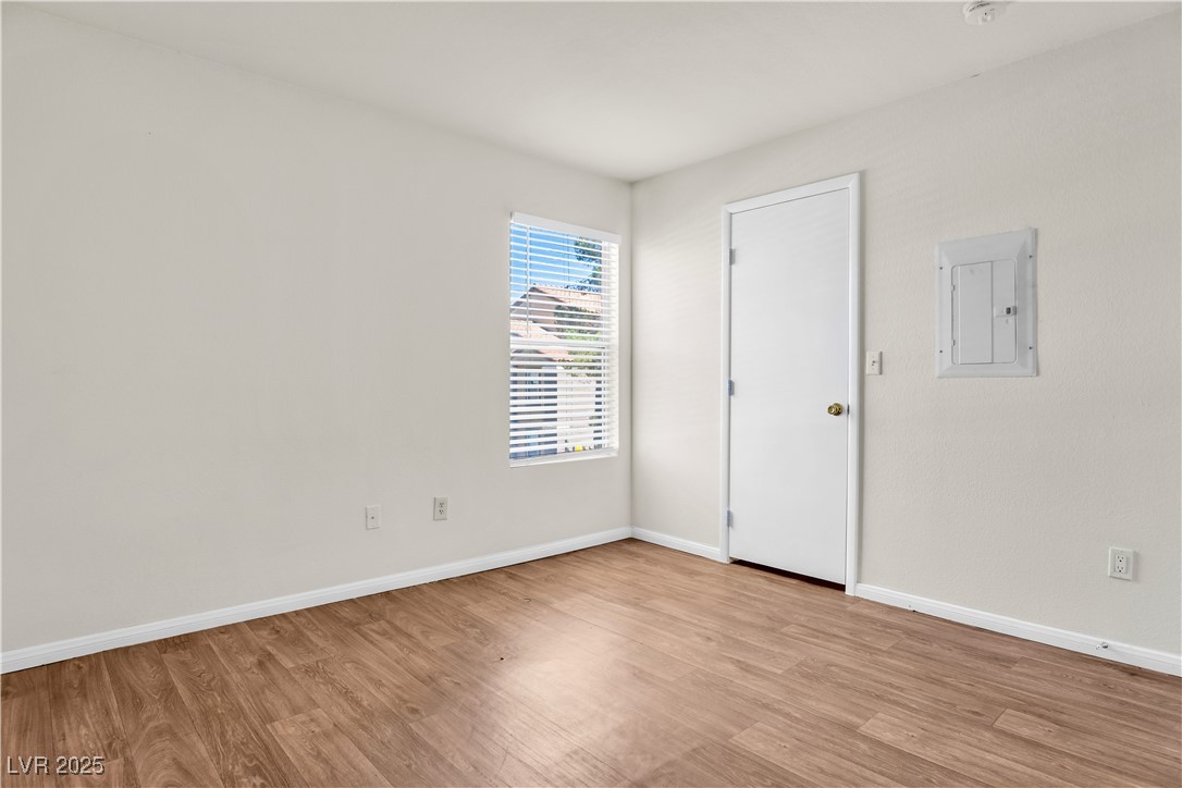 2300 East Silverado Ranch Boulevard, Unit 2003 Las Vegas, NV 89123 - Photo 11 of 19 Empty room with electric panel and light wood-type flooring