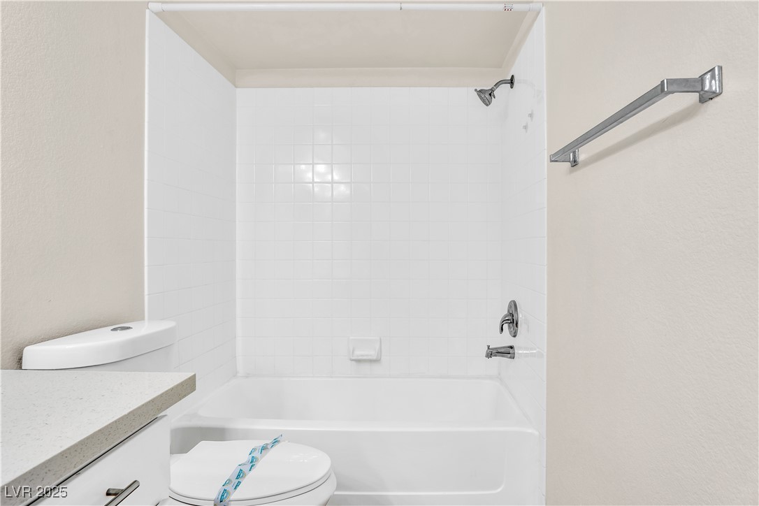 2300 East Silverado Ranch Boulevard, Unit 2003 Las Vegas, NV 89123 - Photo 17 of 19 Full bath with tub / shower combination, vanity, and a textured wall