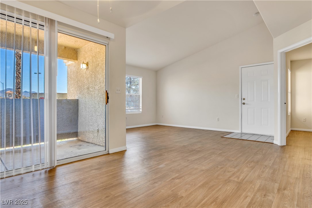 2300 East Silverado Ranch Boulevard, Unit 2003 Las Vegas, NV 89123 - Photo 3 of 19 Empty room with lofted ceiling and light wood finished floors