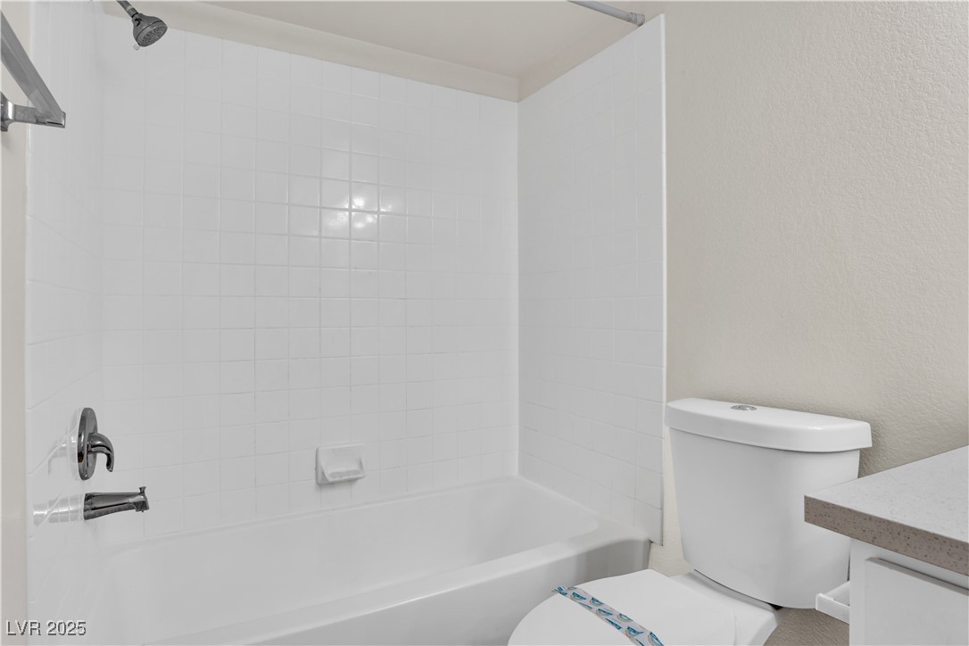 2300 East Silverado Ranch Boulevard, Unit 2003 Las Vegas, NV 89123 - Photo 10 of 19 Bathroom with shower / washtub combination, vanity, and a textured wall