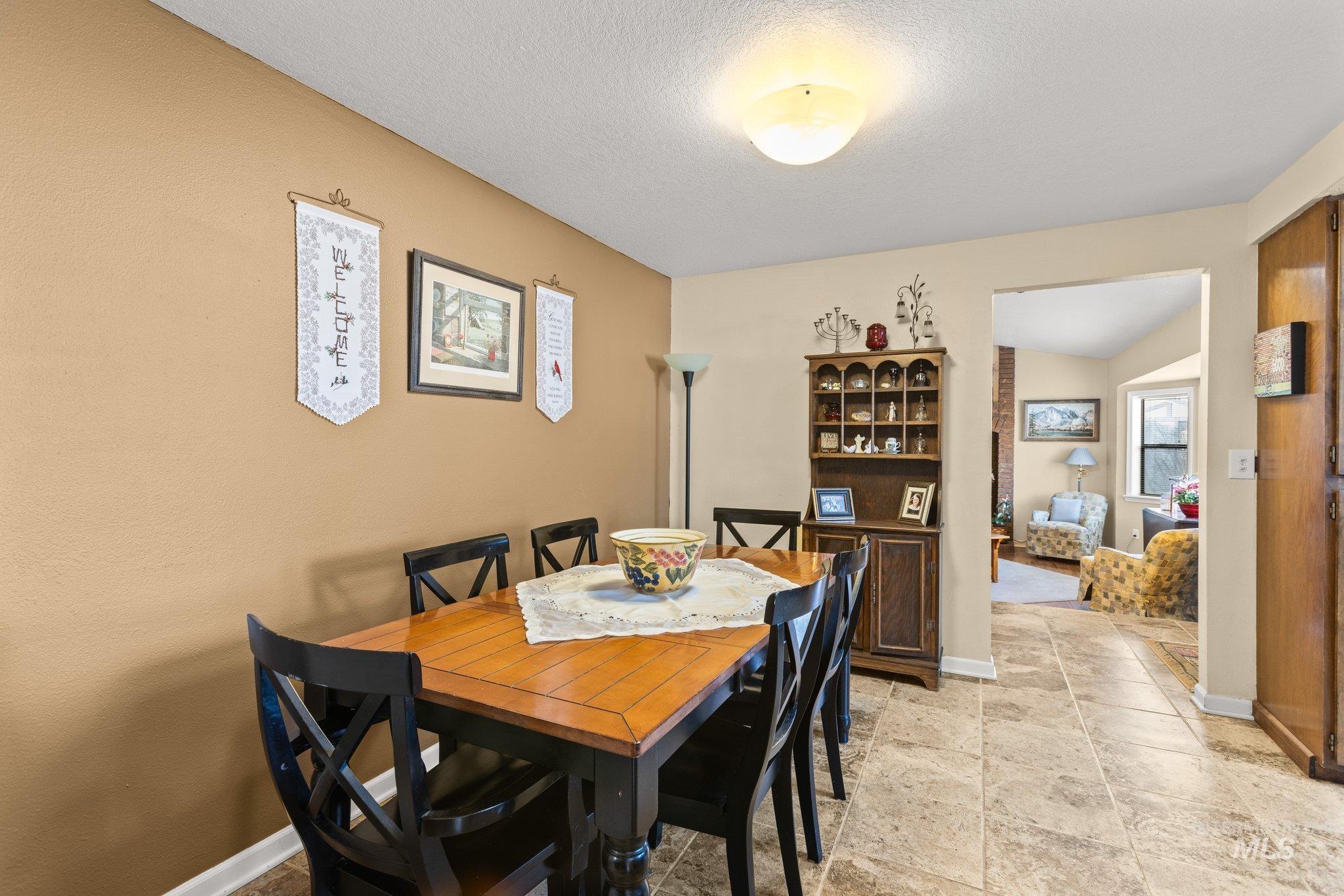 7567 Sundance Drive Boise, ID 83709 - Photo 15 of 21 Dining area with baseboards and a textured ceiling