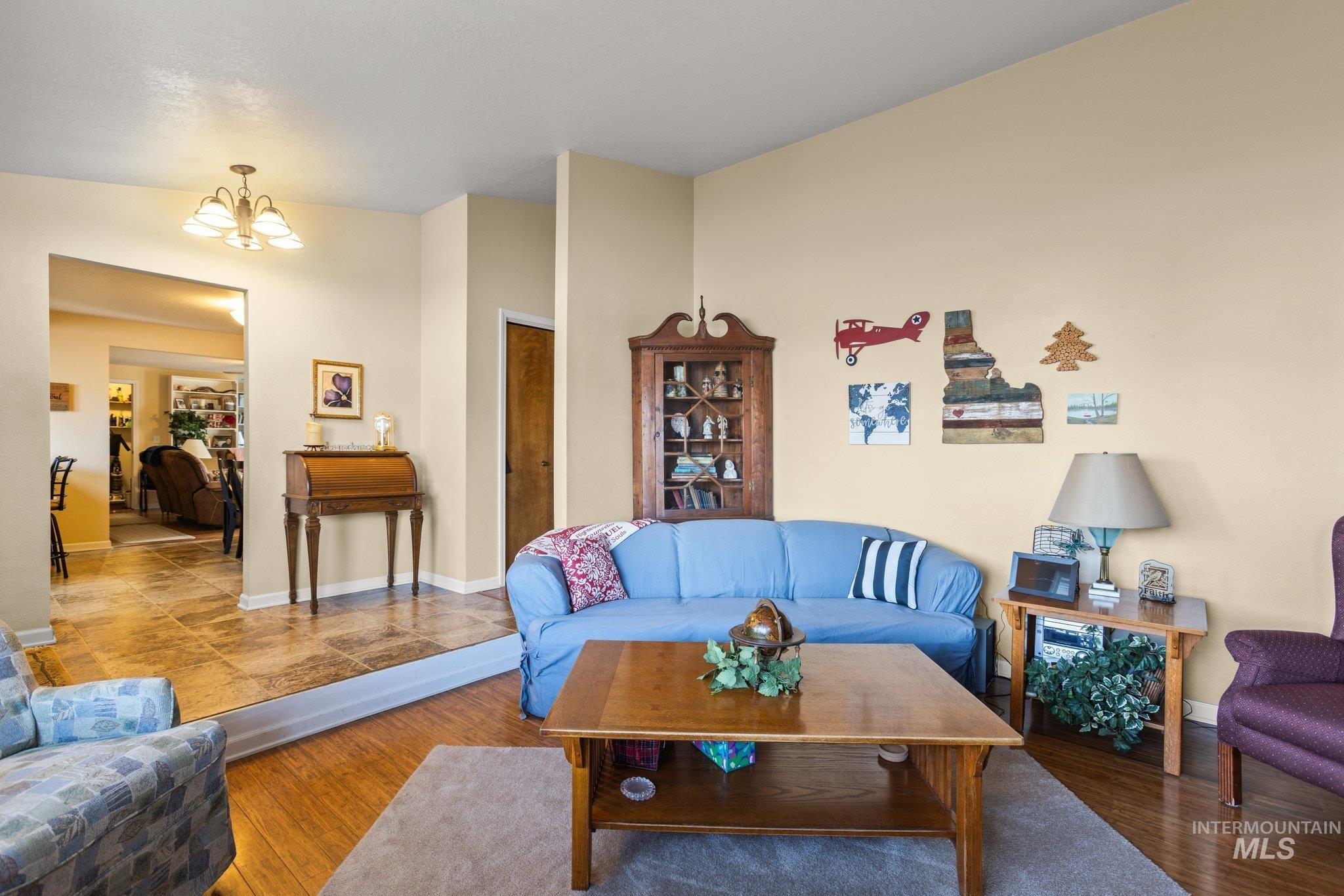 7567 Sundance Drive Boise, ID 83709 - Photo 3 of 21 Living area featuring wood finished floors and a chandelier