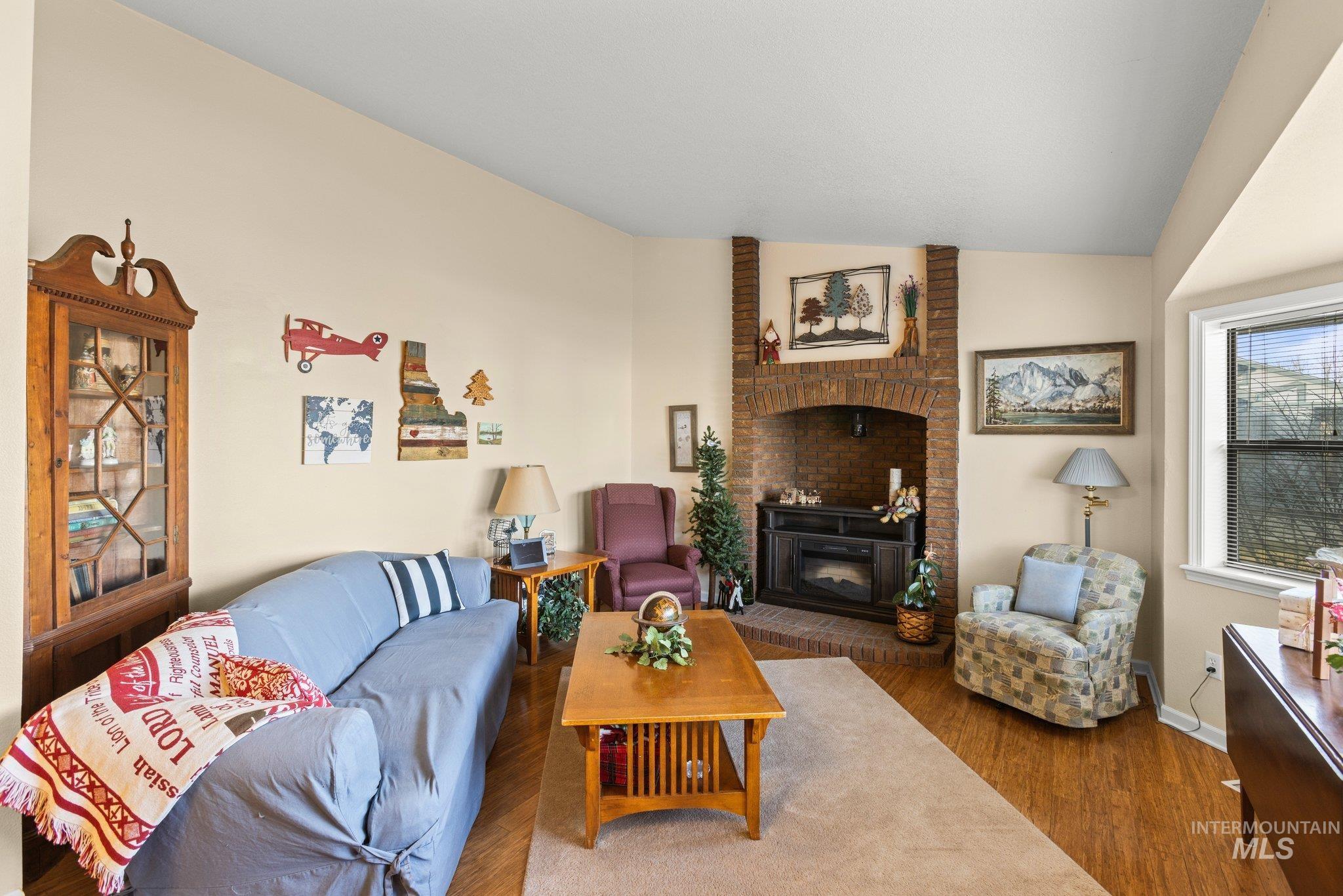 7567 Sundance Drive Boise, ID 83709 - Photo 4 of 21 Living room featuring lofted ceiling, wood finished floors, and a fireplace