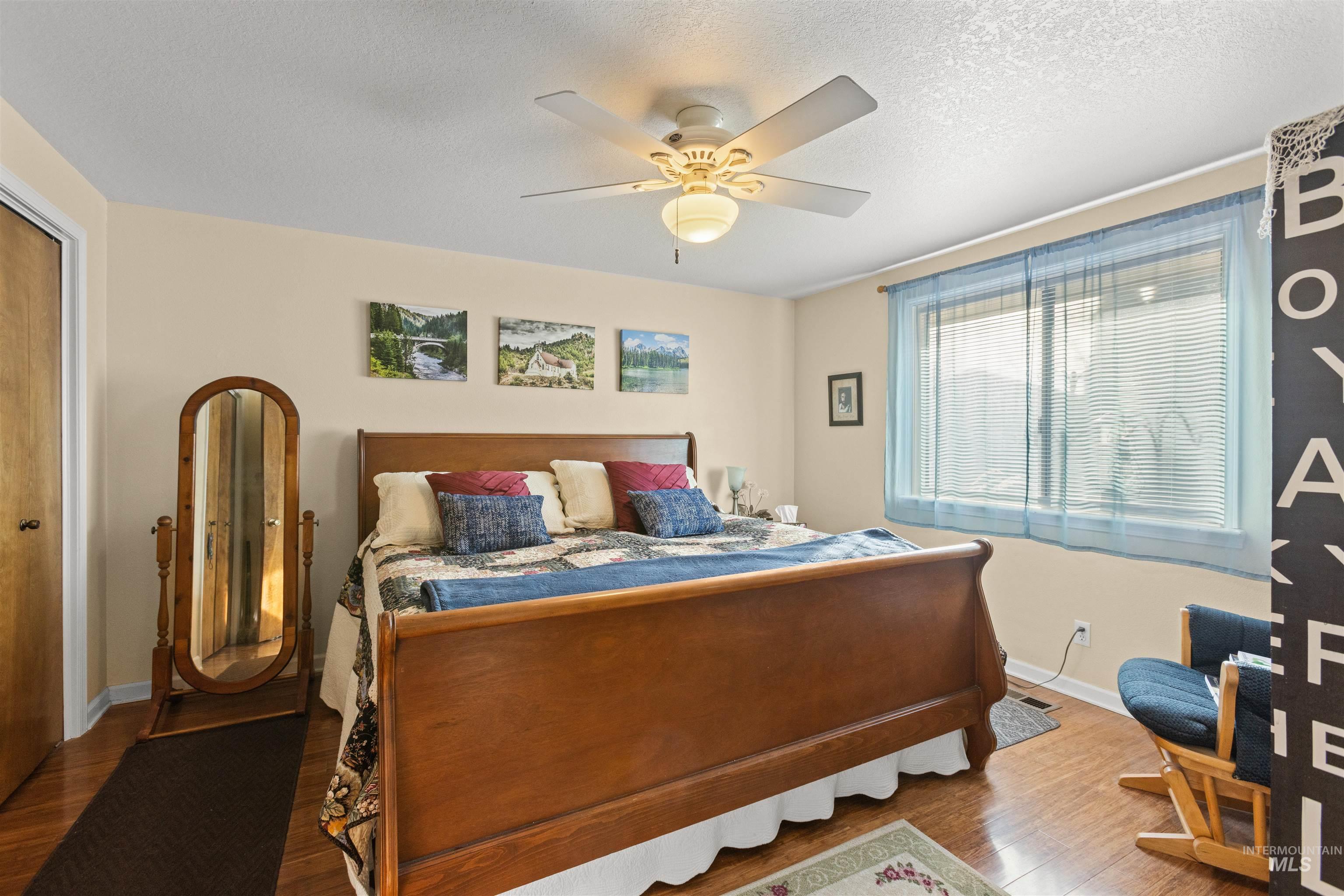 7567 Sundance Drive Boise, ID 83709 - Photo 5 of 21 Bedroom featuring a closet, wood finished floors, a textured ceiling, and a ceiling fan