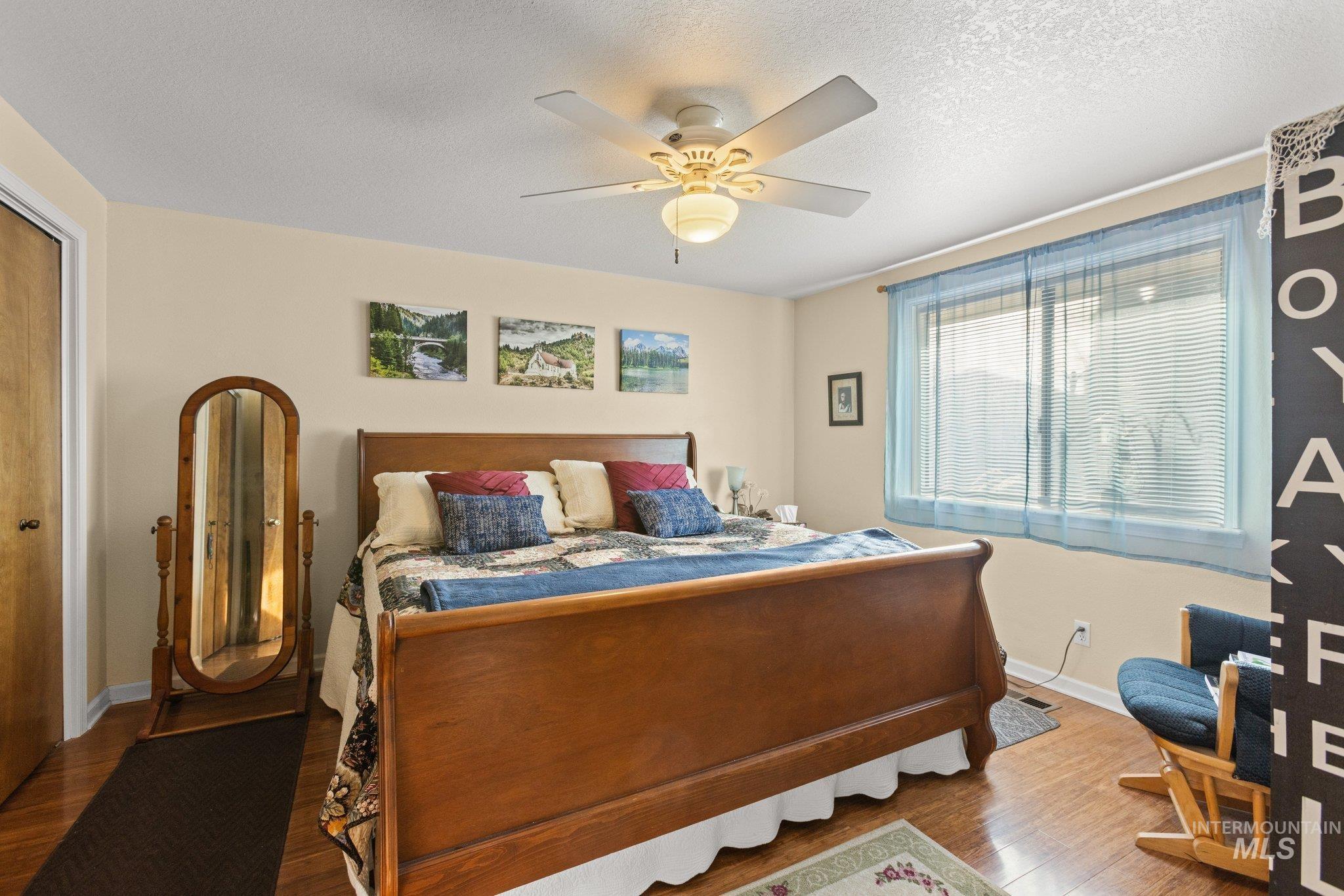 7567 Sundance Drive Boise, ID 83709 - Photo 7 of 21 Bedroom with a closet, wood finished floors, ceiling fan, and a textured ceiling