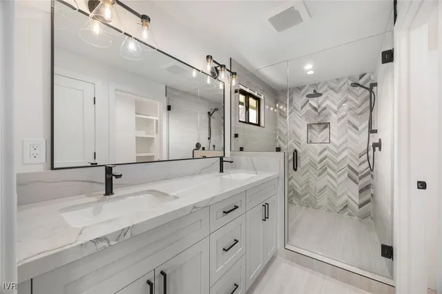 a bathroom with a double vanity sink mirror and shower