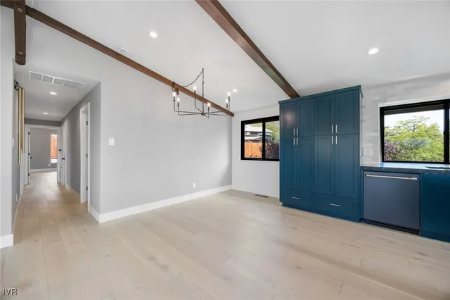 a view of an empty room with window and furniture