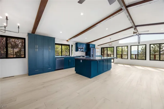 a large kitchen with stainless steel appliances granite countertop a large counter top a stove and a sink