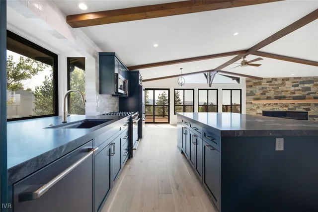 a kitchen with granite countertop a stove a sink and a refrigerator