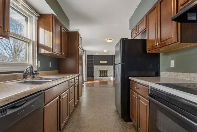 a kitchen with stainless steel appliances granite countertop a refrigerator a stove and a sink