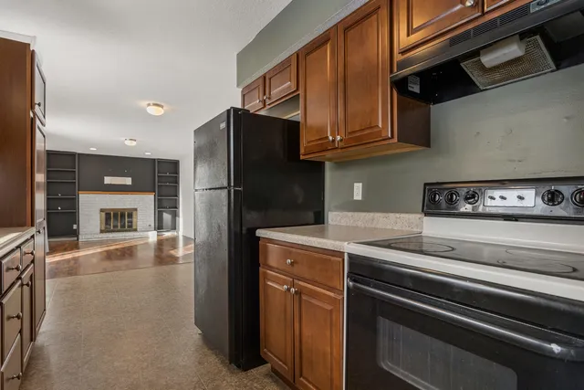 a kitchen with stainless steel appliances granite countertop a refrigerator stove and cabinets
