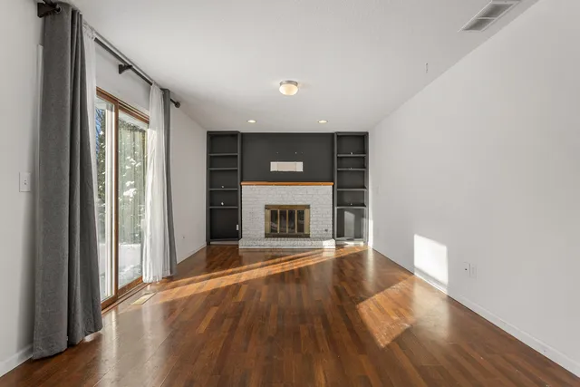 wooden floor in an empty room with a fireplace