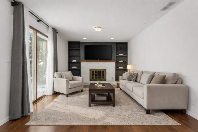 a living room with furniture a fireplace and a flat screen tv