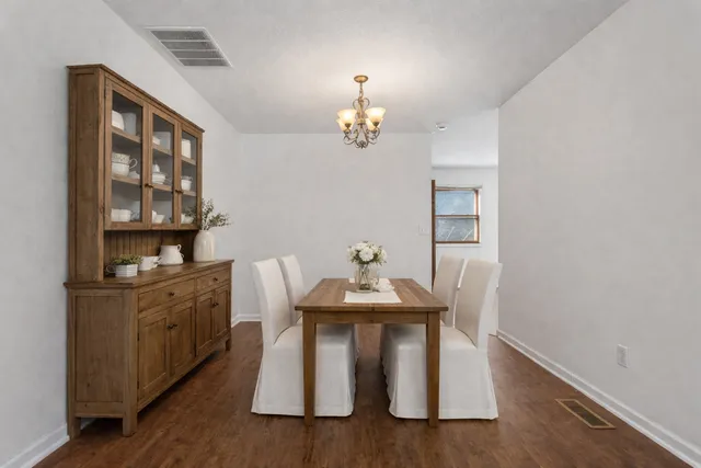 a dining room with table chairs and wooden floor