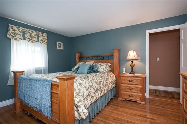 227 West Meadow Road Lowell, MA 01854 - Photo 11 of 25 a bedroom with a bed and wooden floor