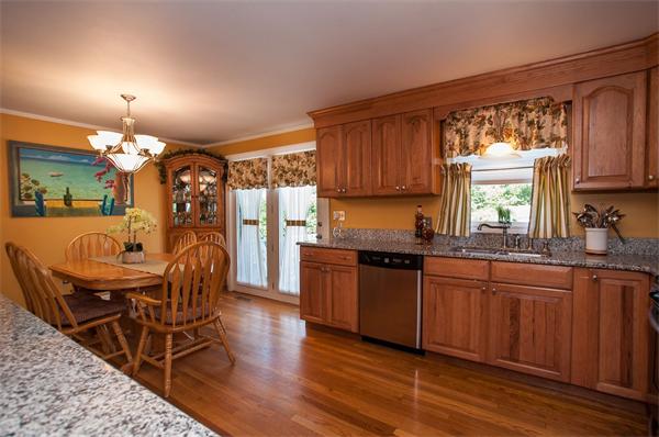 227 West Meadow Road Lowell, MA 01854 - Photo 5 of 25 a kitchen with stainless steel appliances granite countertop wooden floors a stove a sink and white cabinets