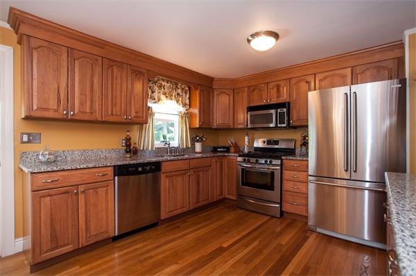 227 West Meadow Road Lowell, MA 01854 - Photo 6 of 25 a kitchen with granite countertop wooden floors stainless steel appliances and a window