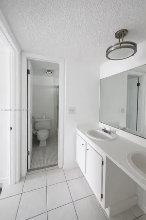 a bathroom with a sink a toilet and a mirror