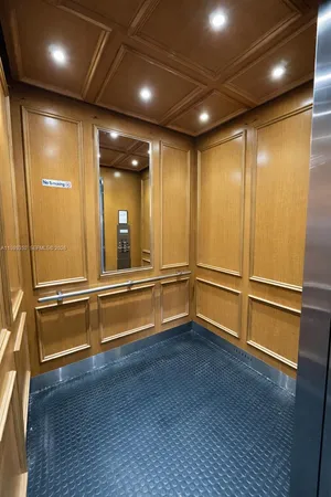a view of an empty room with wooden floor and stairs
