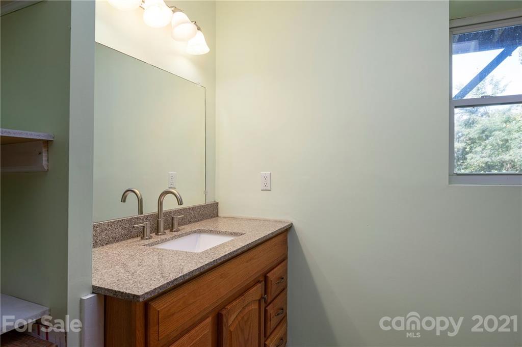 1747 Secluded Valley Road Marshall, NC 28753 - Photo 20 of 33 a bathroom with a granite countertop sink and a mirror