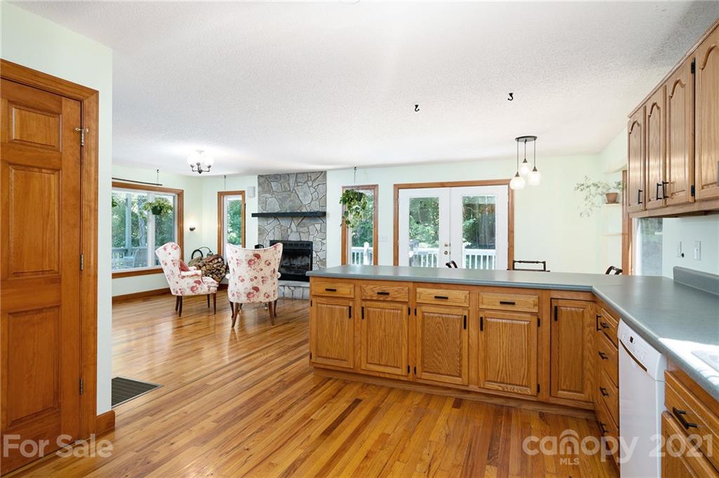 1747 Secluded Valley Road Marshall, NC 28753 - Photo 6 of 33 a large living room with stainless steel appliances granite countertop furniture a large window and a wooden floor