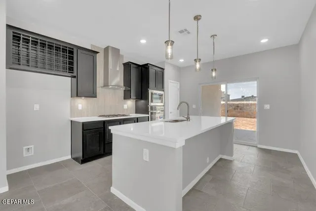 a large kitchen with kitchen island a sink stainless steel appliances and cabinets