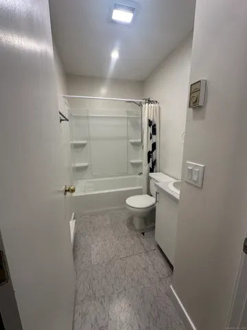 a bathroom with a toilet and a shower