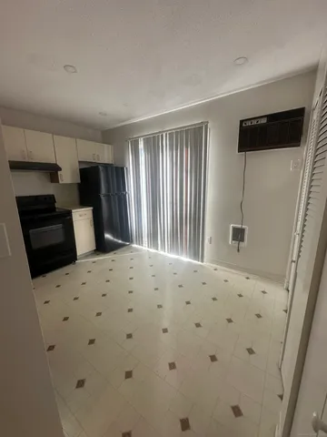 a bedroom with a bed and a refrigerator