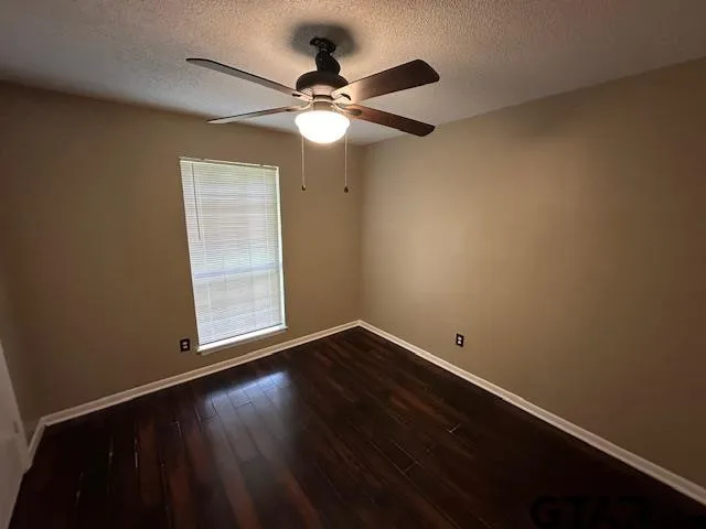 an empty room with a window and wooden floor