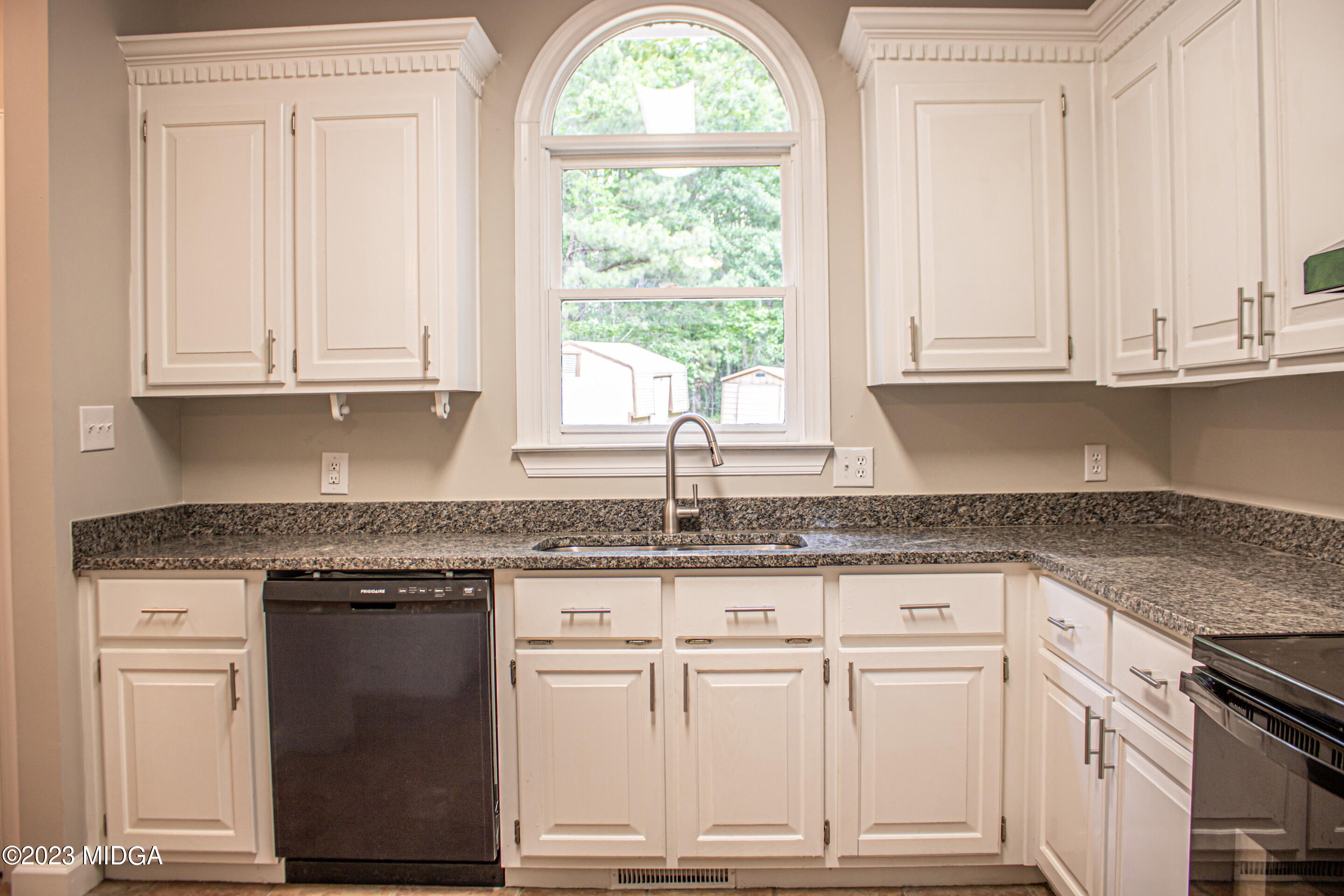 2818 Pea Ridge Road Juliette, GA 31046 - Photo 25 of 71 a kitchen with granite countertop white cabinets and a window