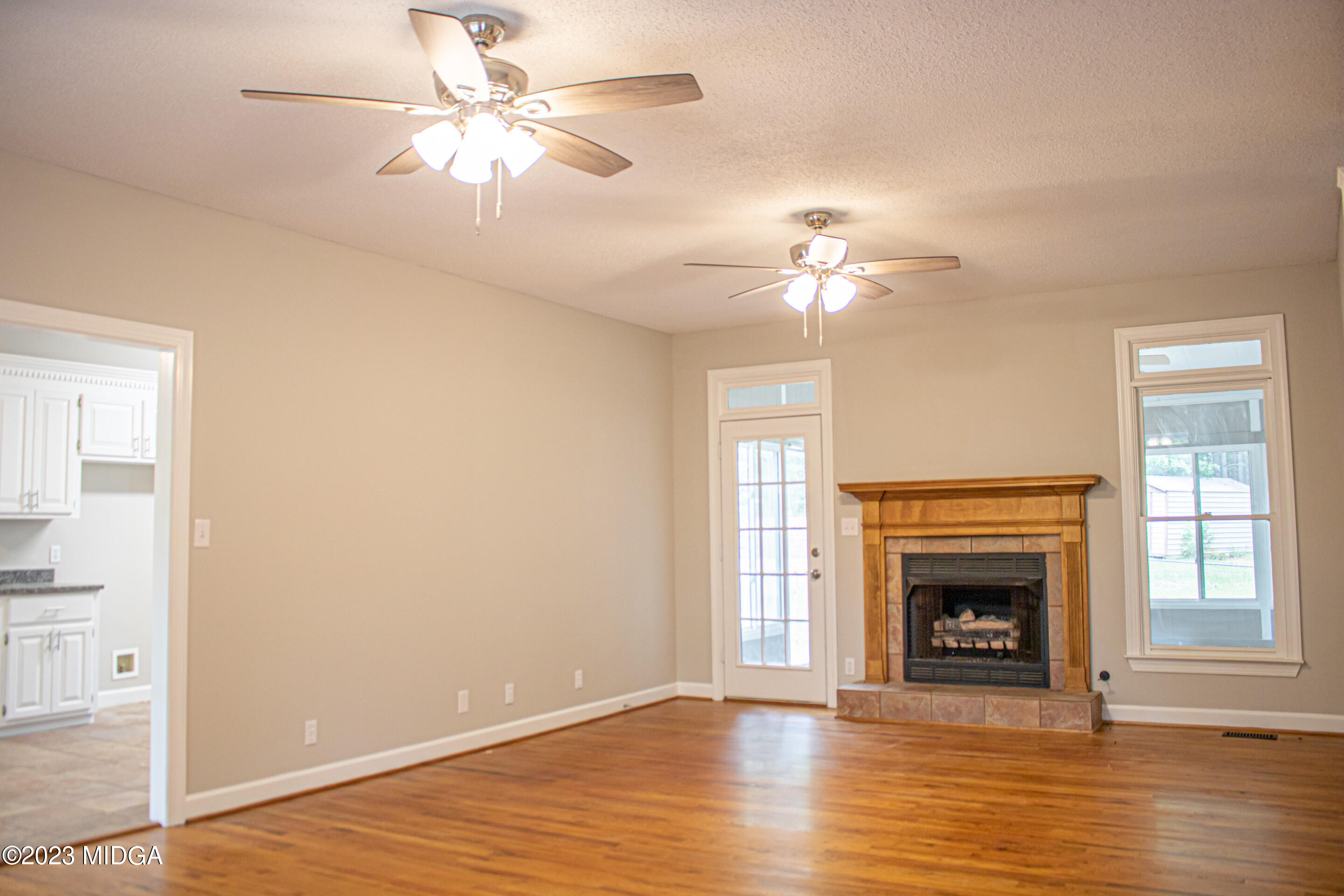 2818 Pea Ridge Road Juliette, GA 31046 - Photo 3 of 71 a view of a livingroom with a ceiling fan a fireplace and wooden floor