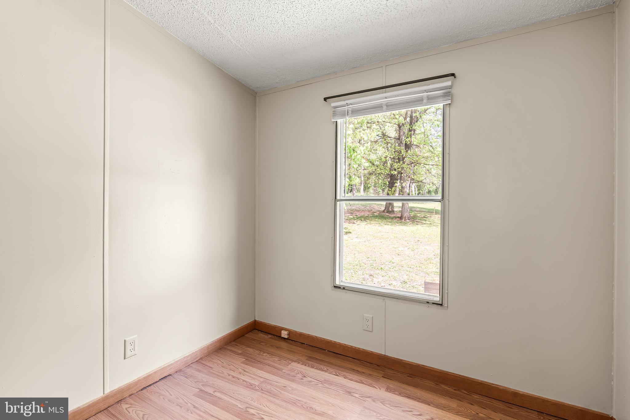 1217 Nestle Quarry Road Falling Waters, WV 25419 - Photo 31 of 52 a view of an empty room with wooden floor and a window