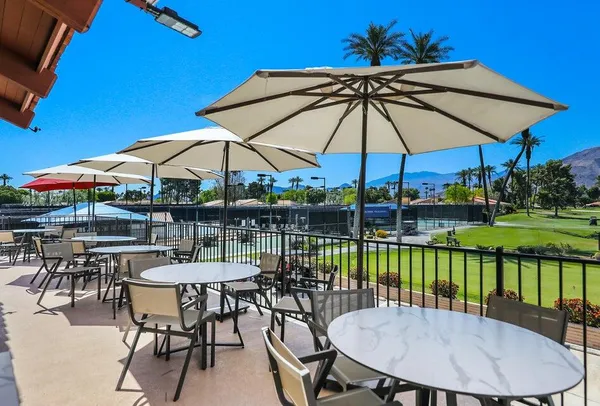 a view of a swimming pool with a table and chairs under an umbrella