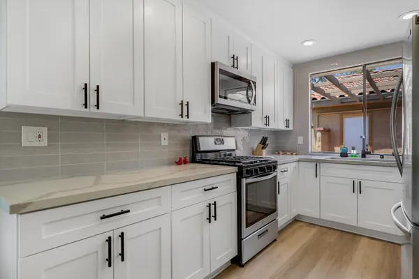 a kitchen with white cabinets stainless steel appliances and sink