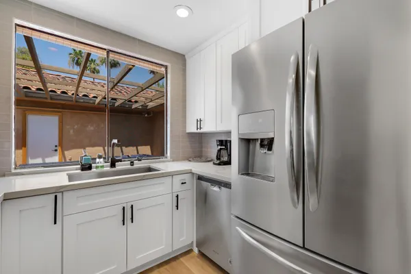 a kitchen with stainless steel appliances a sink and a refrigerator