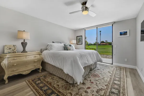 a bedroom with a bed and a lamp on dresser