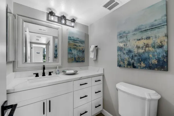 a bathroom with a sink a toilet and a mirror