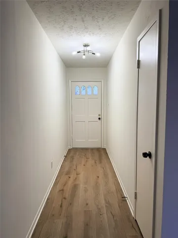 a view of a hallway with wooden floor