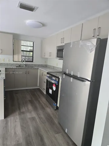 a kitchen with a sink stainless steel appliances and cabinets