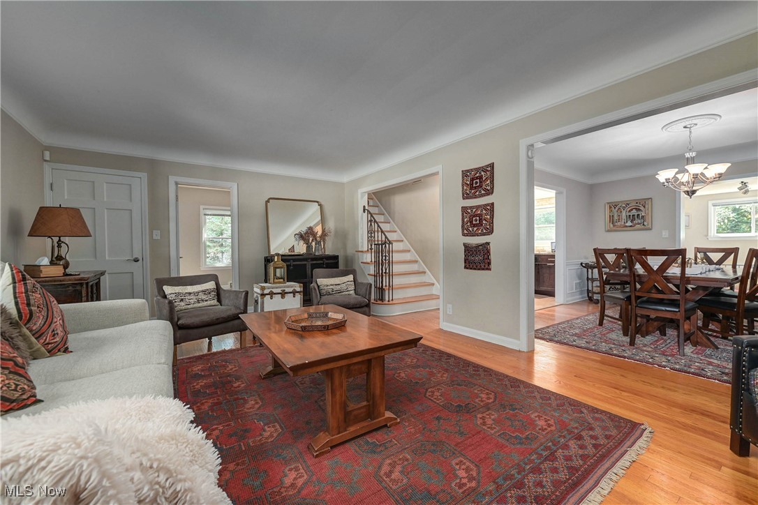 4022 Hillbrook Road Cleveland, OH 44118 - Photo 10 of 49 Living room with stairs, light wood-style flooring, and a chandelier